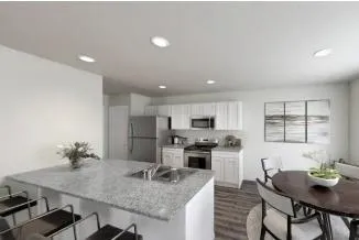 a kitchen with kitchen island a stove a table and chairs in it