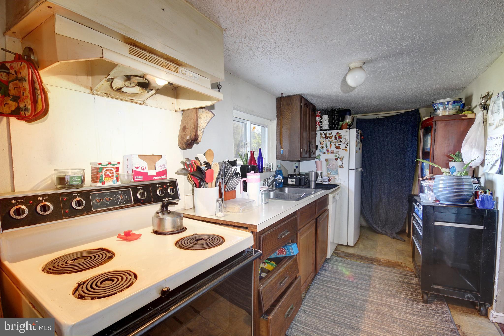 11 West Chestnut Street Delmar, MD 21875 - Photo 6 of 14 a kitchen with kitchen island a stove a sink dishwasher and a dining table with wooden floor