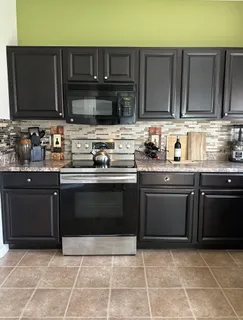 a kitchen with stainless steel appliances granite countertop a stove a sink and a microwave