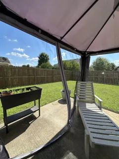 a view of a chairs and table in patio with a yard