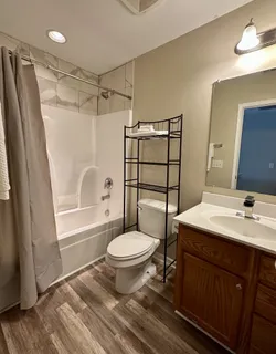 a bathroom with a sink toilet a mirror and shower
