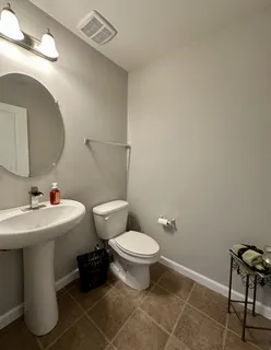 a bathroom with a sink toilet and a mirror
