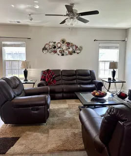 a living room with furniture ceiling fan and a window