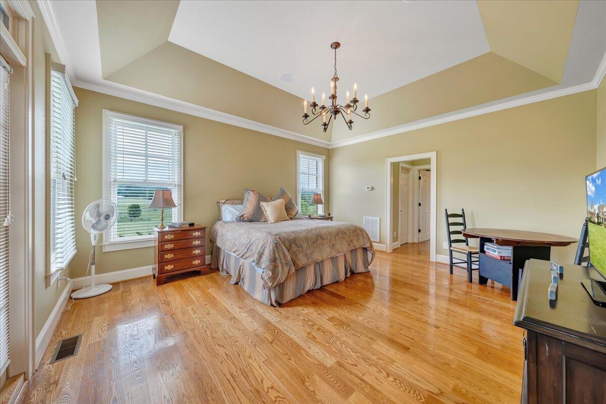 400 Quail Ridge Drive Fincastle, VA 24090 - Photo 32 of 113 a spacious bedroom with a bed a chandelier and a large window