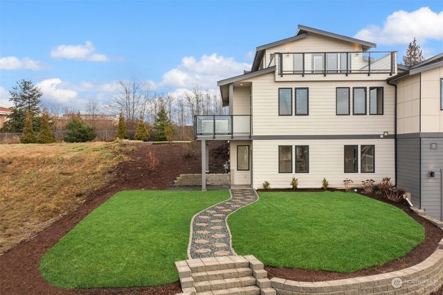 an aerial view of a house with a yard and lake view