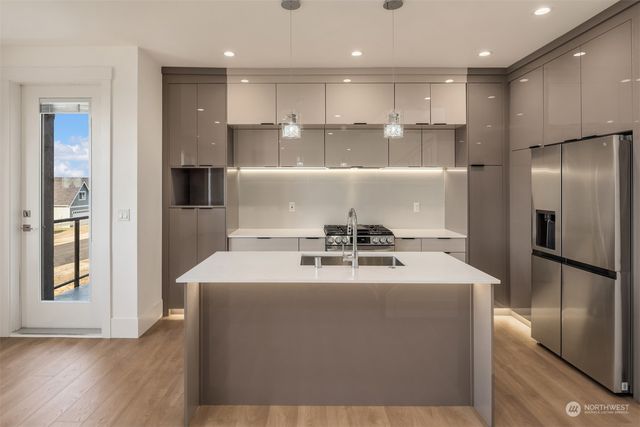 a large kitchen with kitchen island a sink stainless steel appliances and cabinets