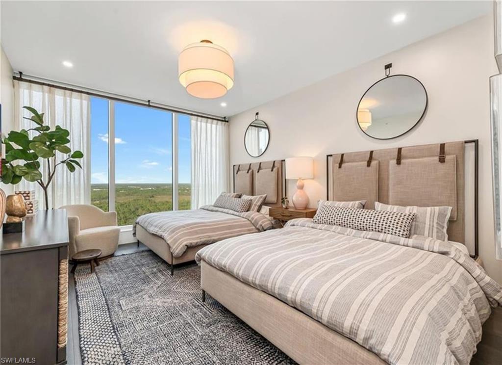 13925 Old Coast Road, Unit 2201 Naples, FL 34110 - Photo 14 of 28 a bedroom with two beds and a large mirror