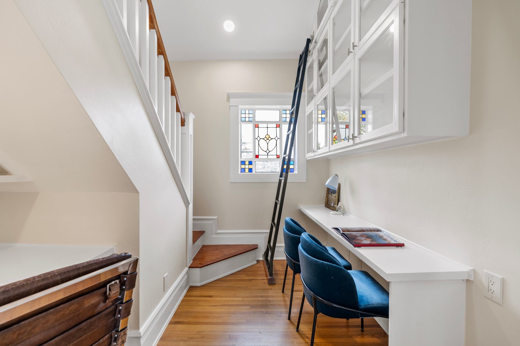 607 Harvard Street Houston, TX 77007 - Photo 28 of 50 The second-floor library is the perfect spot for work or study thanks to its built-in desks, glass cabinetry, loft storage, library ladder and stained glass window.