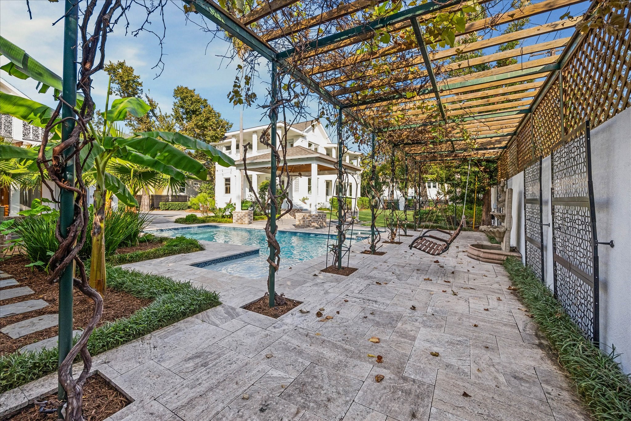 607 Harvard Street Houston, TX 77007 - Photo 3 of 50 A classic bench swing and water feature invite you to relax under the lovely pergola.