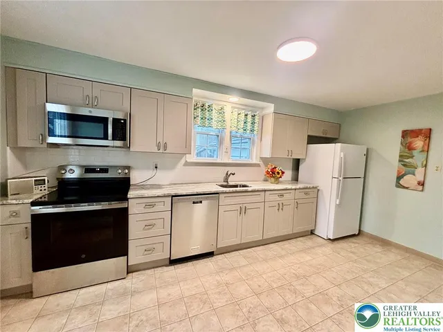 a kitchen with a sink cabinets and stainless steel appliances