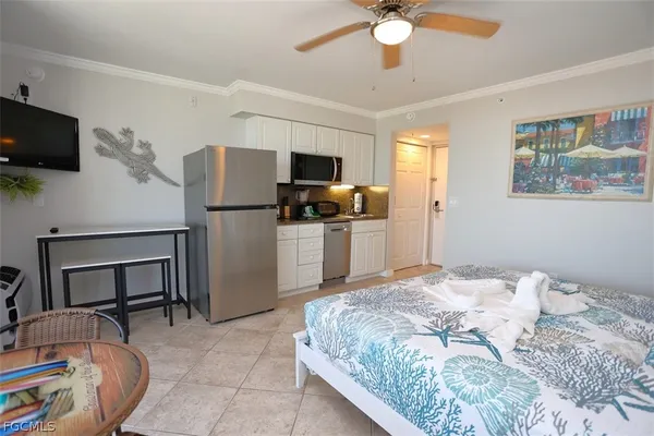 a bedroom with a bed a couch and a flat screen tv