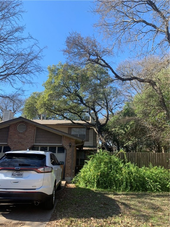 a view of car parked on road with wooden fence