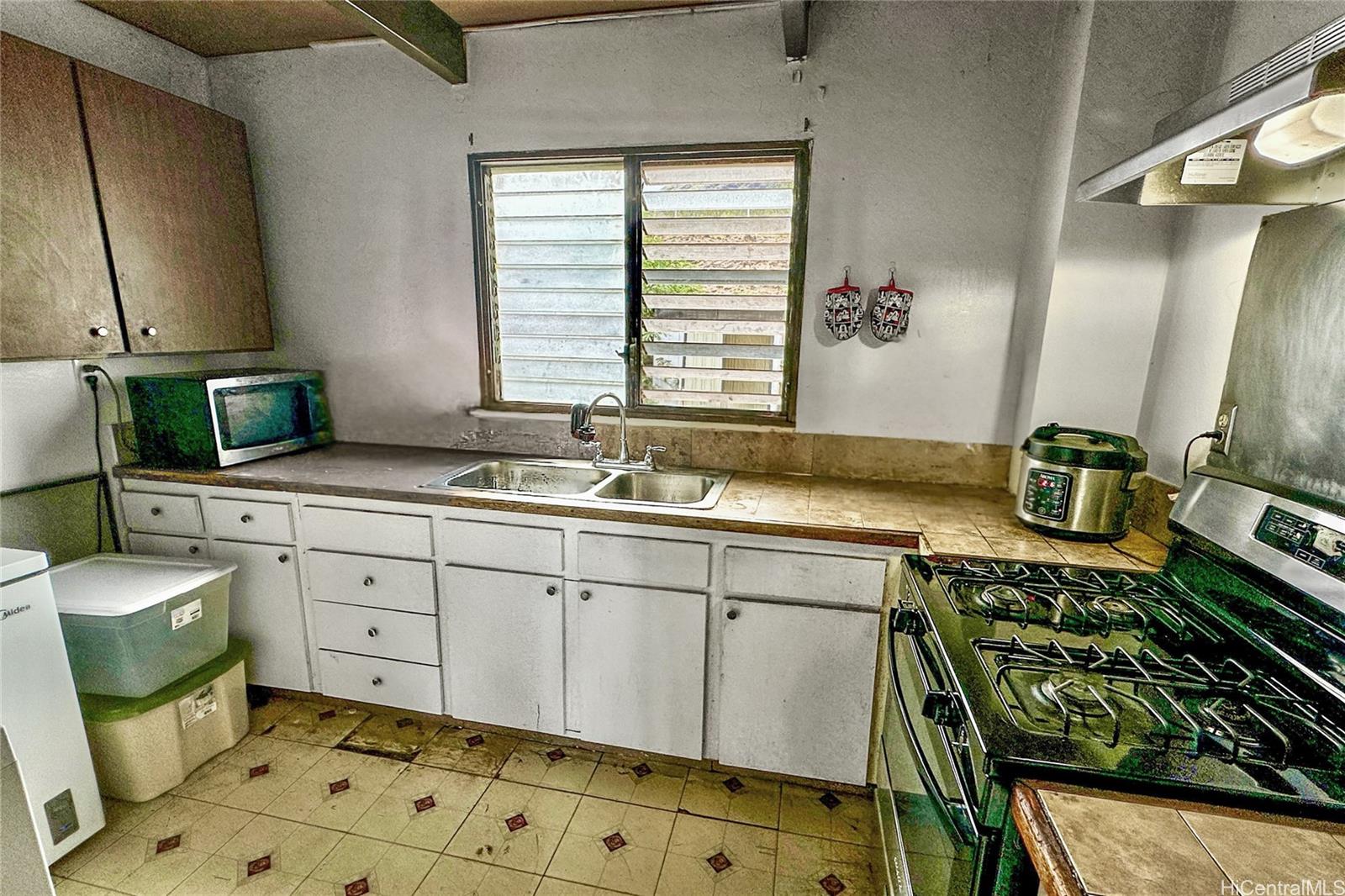 87217 Helelua Street, Unit 1 Waianae, HI 96792 - Photo 11 of 15 a kitchen with sink cabinets and appliances