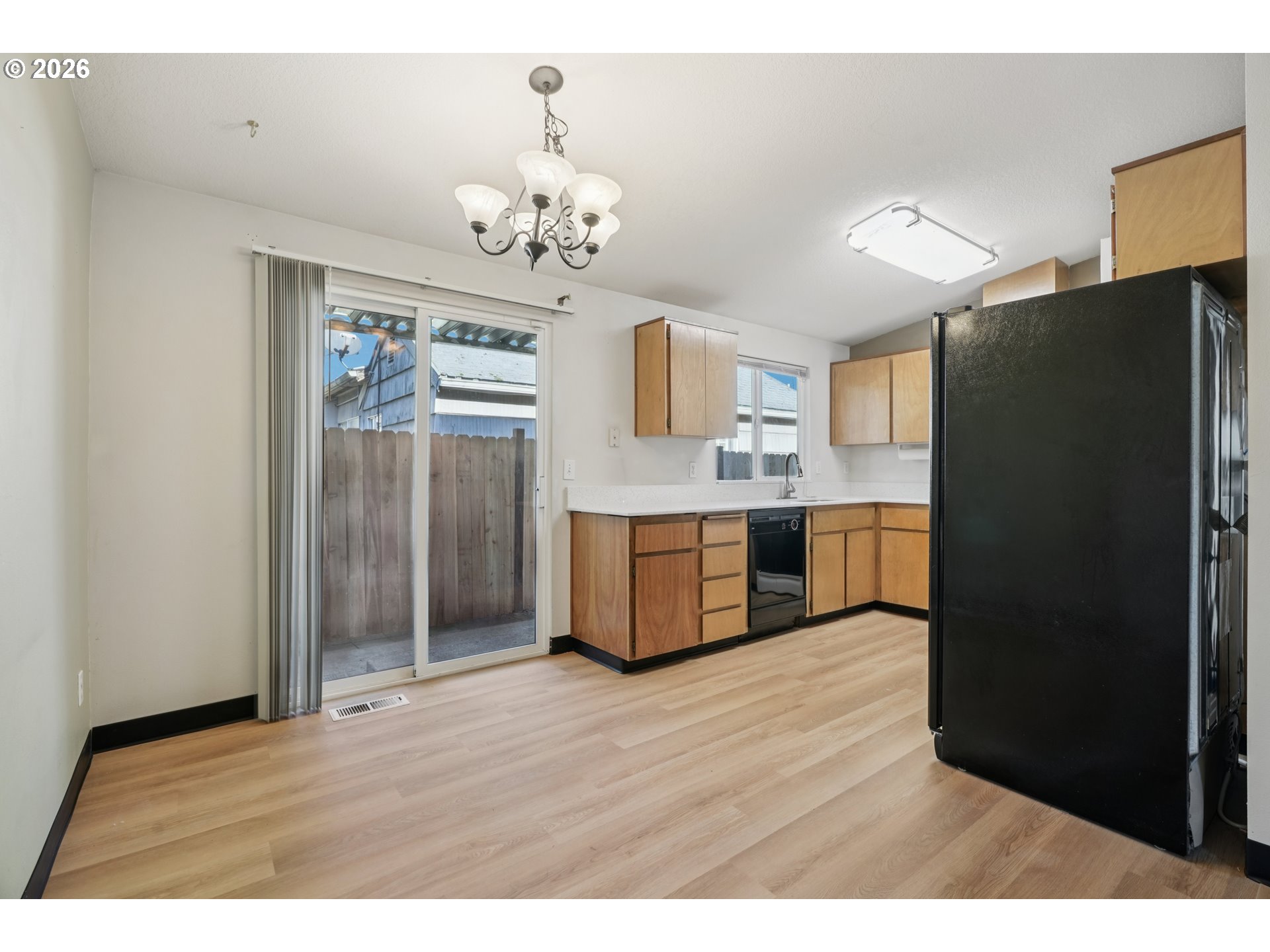7306 Southeast 76th Avenue Portland, OR 97206 - Photo 10 of 34 a kitchen with stainless steel appliances a refrigerator and a wooden floor