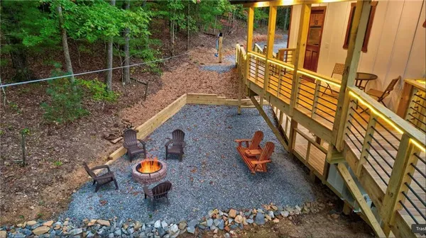 a view of a wooden chairs and table in the backyard