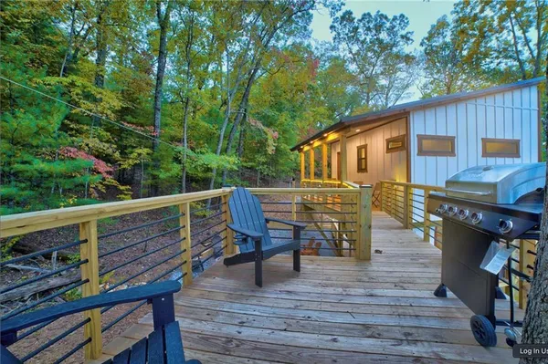 a view of a house with a yard chairs and a wooden deck