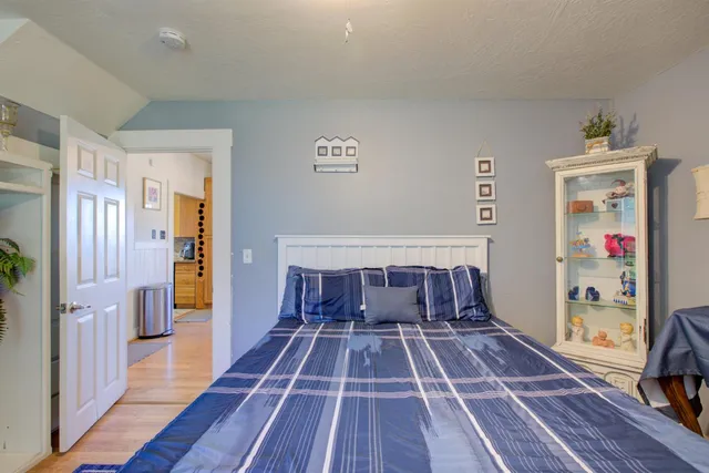 a bedroom with a bed a couch and a flat tv screen on dresser