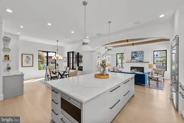 a large kitchen with kitchen island a stove a sink a dining table and chairs