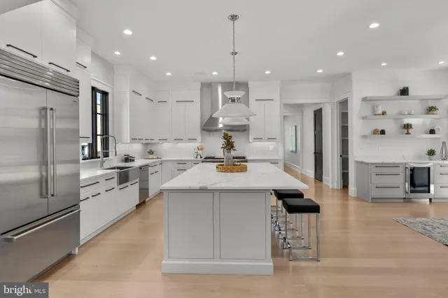 a kitchen with stainless steel appliances kitchen island granite countertop a refrigerator and a stove top oven
