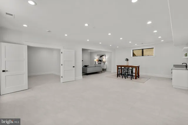 a kitchen with stainless steel appliances kitchen island a table and chairs in it