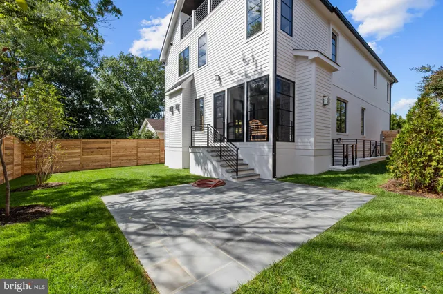 a view of a white house with a small yard and plants