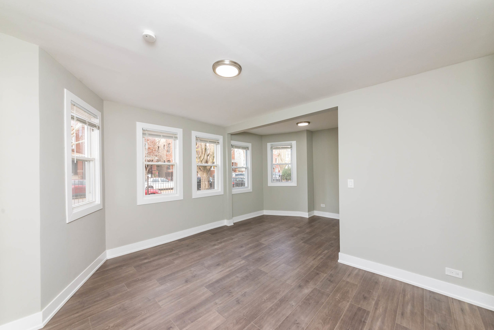 2923 North Avers Avenue, Unit 1 Chicago, IL 60618 - Photo 2 of 17 a view of an empty room with wooden floor and a window
