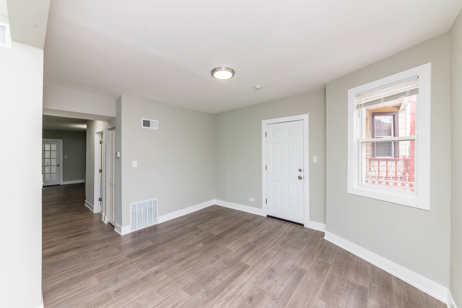 2923 North Avers Avenue, Unit 1 Chicago, IL 60618 - Photo 3 of 17 an empty room with wooden floor and windows