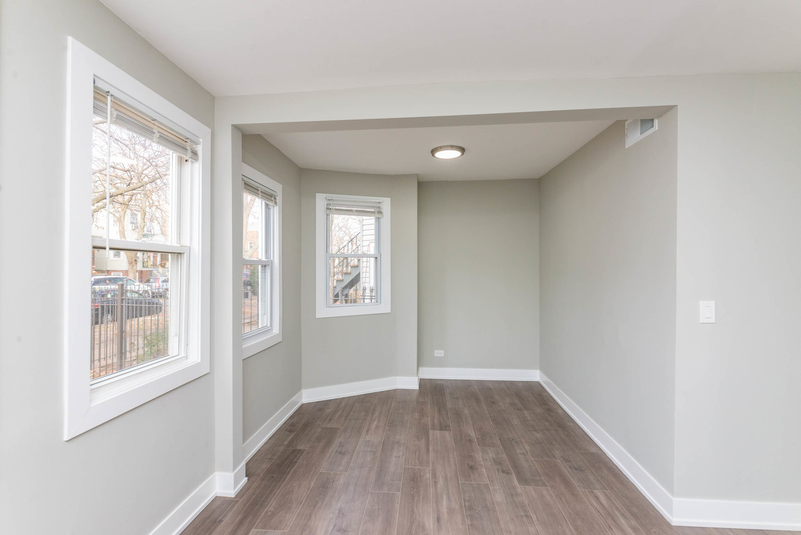 2923 North Avers Avenue, Unit 1 Chicago, IL 60618 - Photo 4 of 17 an empty room with wooden floor and windows