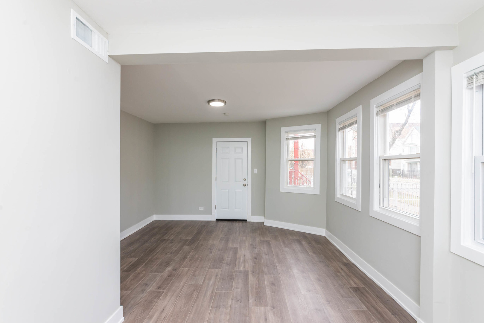 2923 North Avers Avenue, Unit 1 Chicago, IL 60618 - Photo 5 of 17 an empty room with wooden floor and windows