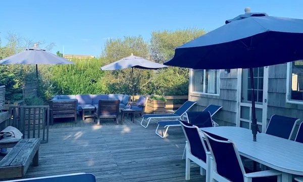 a view of a patio with a dining table and chairs under an umbrella