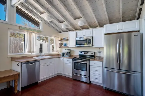 a kitchen with stainless steel appliances granite countertop a refrigerator a stove a sink dishwasher a microwave oven with cabinets and wooden floor