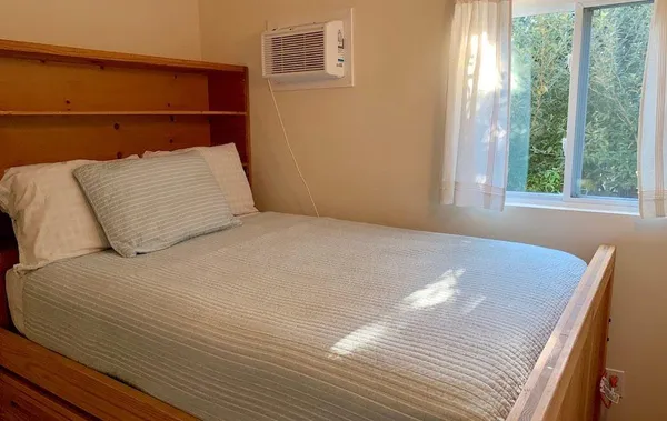 a bed sitting in a bedroom next to a window