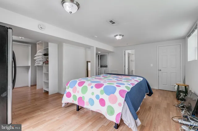 a bedroom with a bed and wooden floor