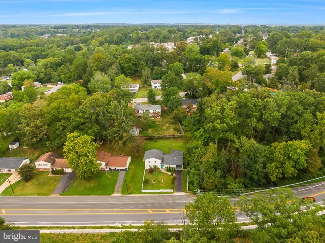 an aerial view of a residential houses with yard and lake view