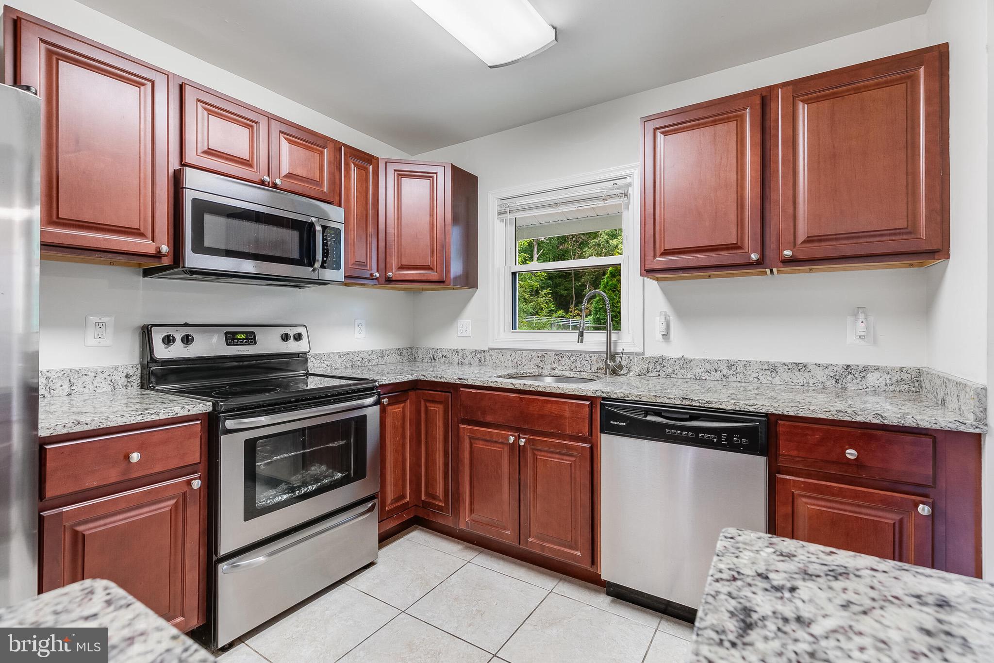 6624 Telegraph Road Alexandria, VA 22310 - Photo 6 of 36 a kitchen with stainless steel appliances granite countertop a stove sink microwave and cabinets