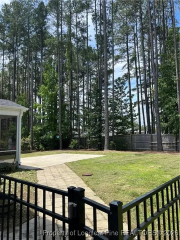 a view of swimming pool with lawn chairs and plants