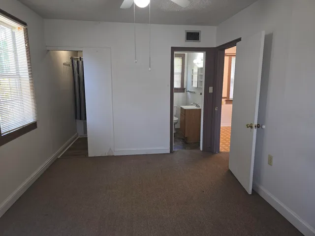 an empty room with closet and windows
