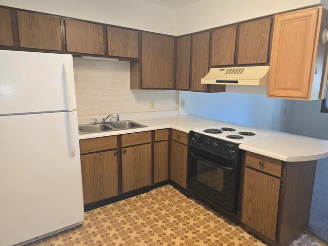 a kitchen with a refrigerator sink and cabinets