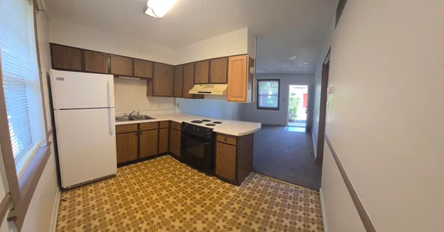 a kitchen with a refrigerator sink and cabinets
