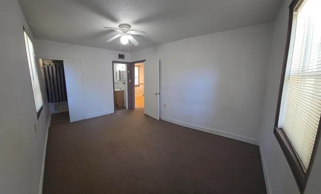 an empty room with windows and closet