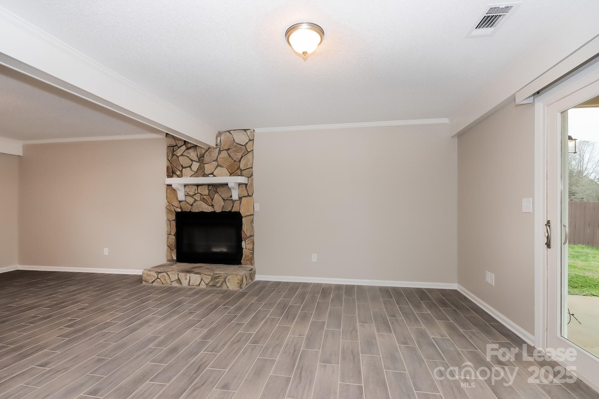 148 Mooreland Road Mooresville, NC 28117 - Photo 2 of 17 a view of empty room with wooden floor and fireplace