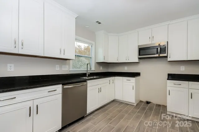 a kitchen with granite countertop white cabinets and white appliances