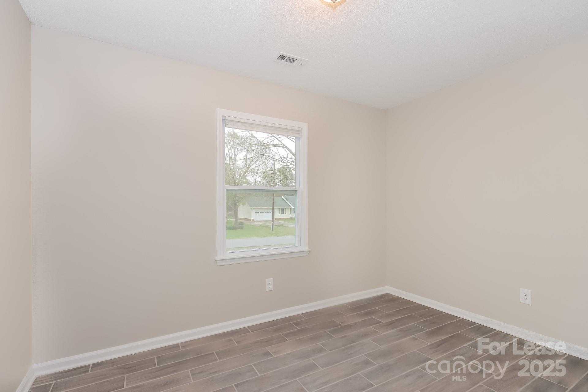 148 Mooreland Road Mooresville, NC 28117 - Photo 10 of 17 an empty room with wooden floor and windows