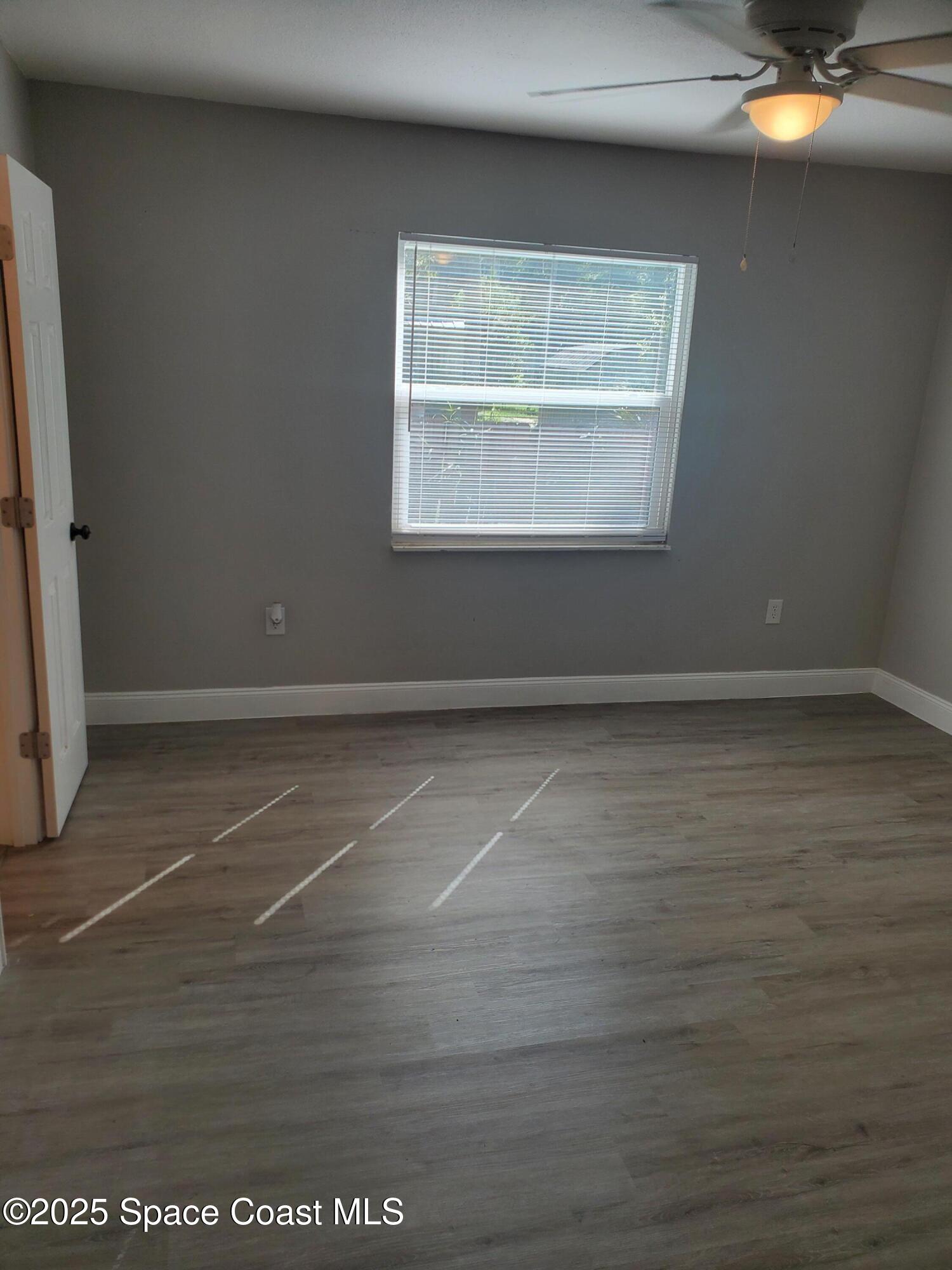 1105 Santa Rosa Drive Rockledge, FL 32955 - Photo 11 of 16 an empty room with wooden floor and windows