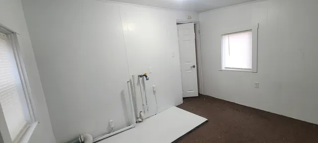 a kitchen with a refrigerator a sink and wooden floor