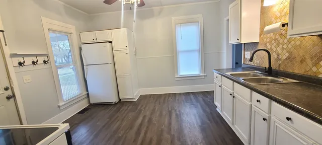 a kitchen with granite countertop white cabinets and white appliances