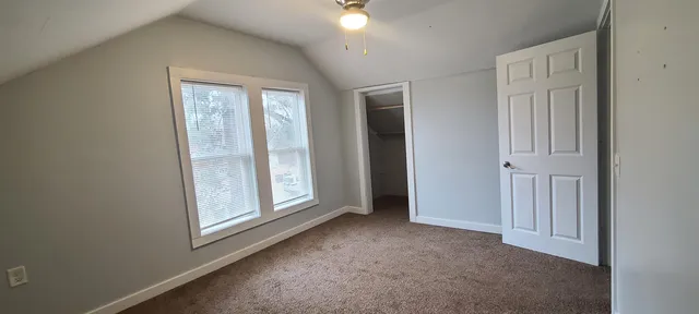 an empty room with windows and closet