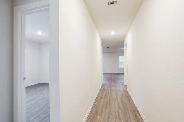 a view of a hallway with wooden floor