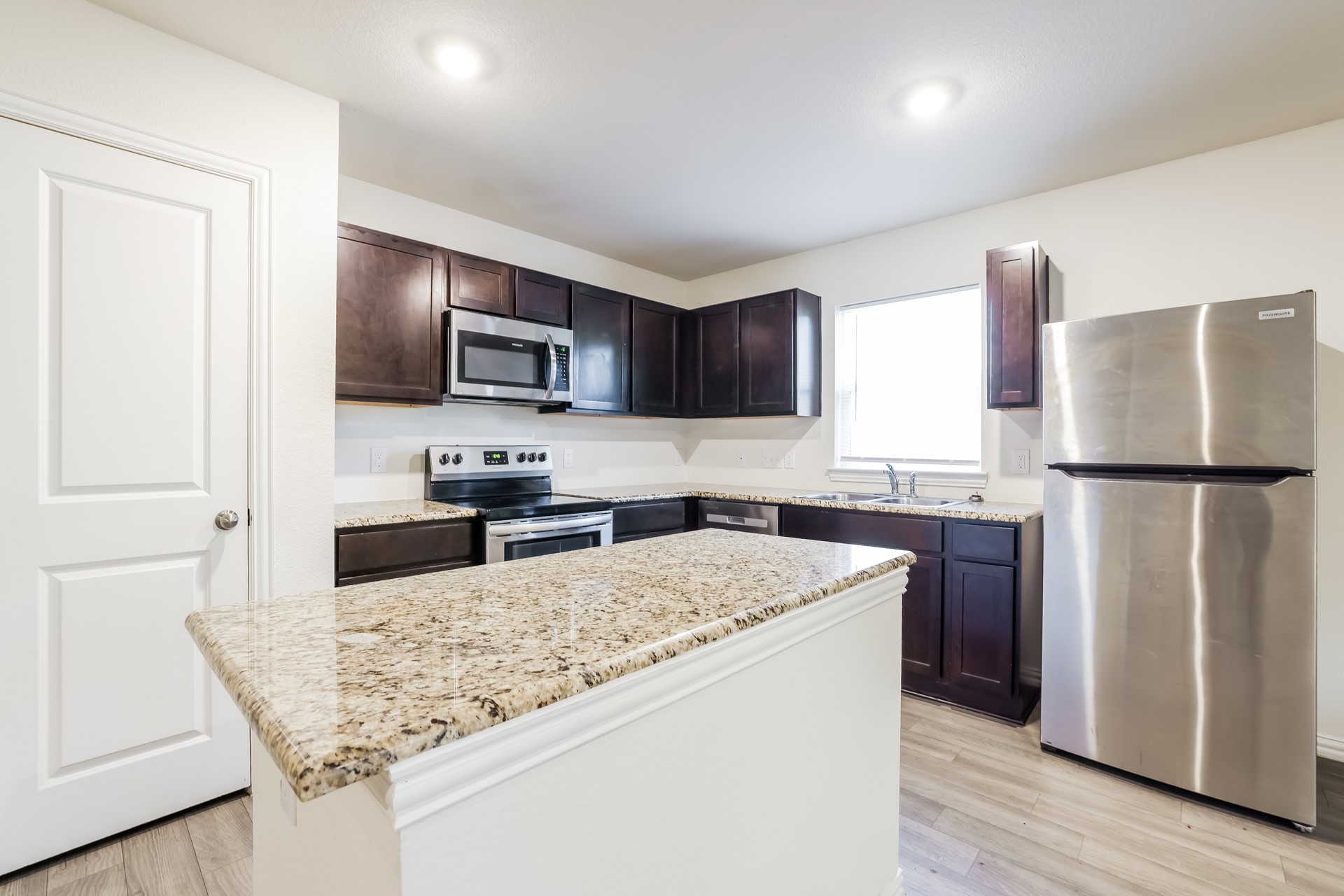 8213 Linda Vista Road Houston, TX 77028 - Photo 7 of 21 a kitchen with granite countertop a refrigerator and a stove top oven