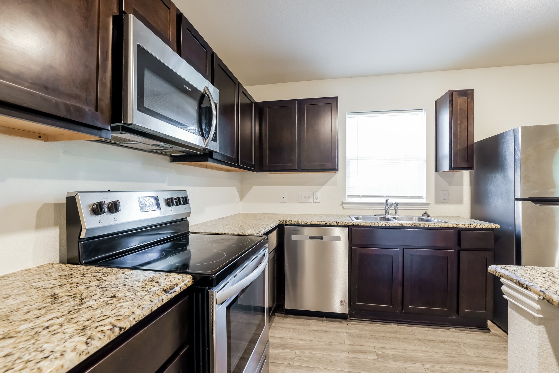 8213 Linda Vista Road Houston, TX 77028 - Photo 8 of 21 a kitchen with stainless steel appliances granite countertop a sink stove microwave and refrigerator